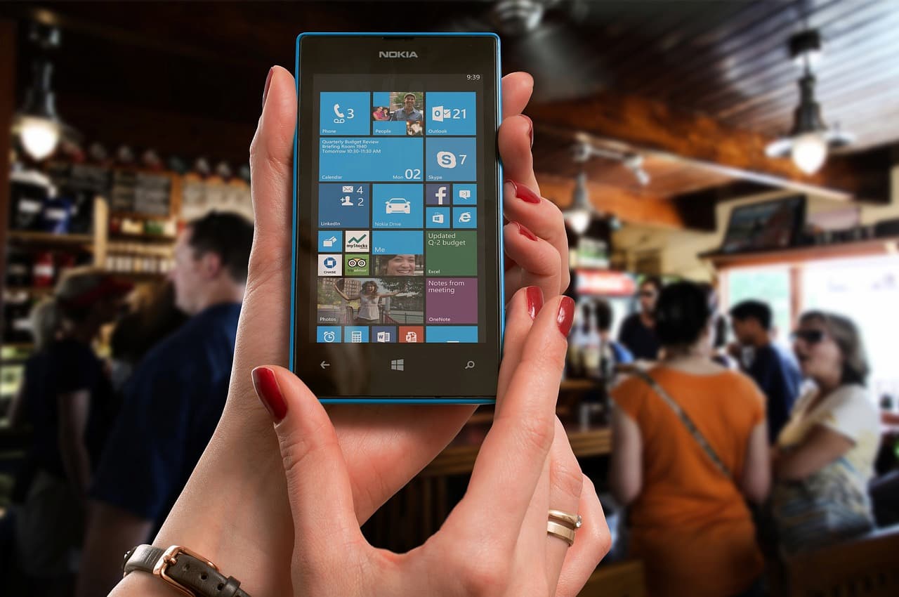 Imagem de um celular com o sistema da Microsoft na mão de uma pessoa