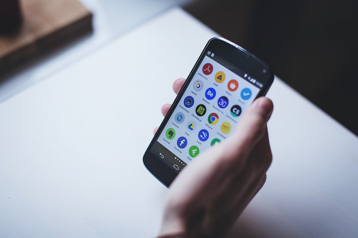 Um celular android com vários aplicativos em sua tela na mão de uma pessoa
