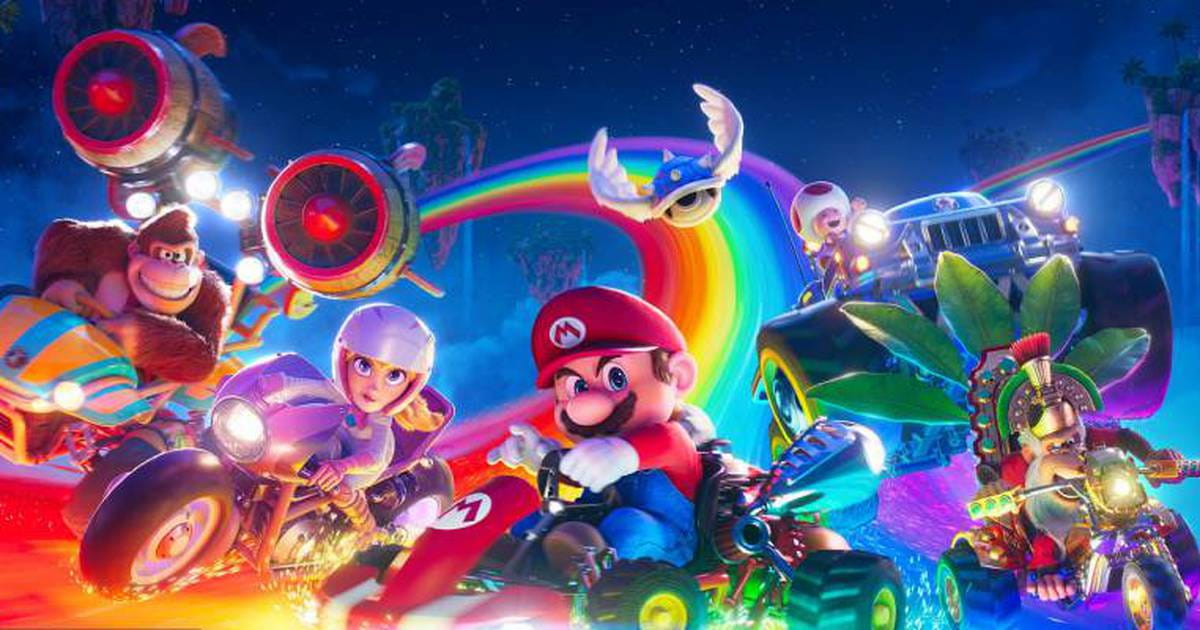 Personagens do jogo Mario no filme em carrinhos numa pista arco-iris no universo