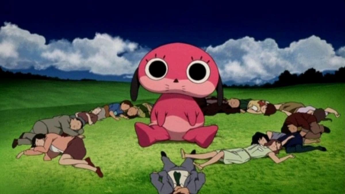especie de cachorro rosa gigante com um circulo de pessoas deitadas ao redor em um campo no anime paranoia agent