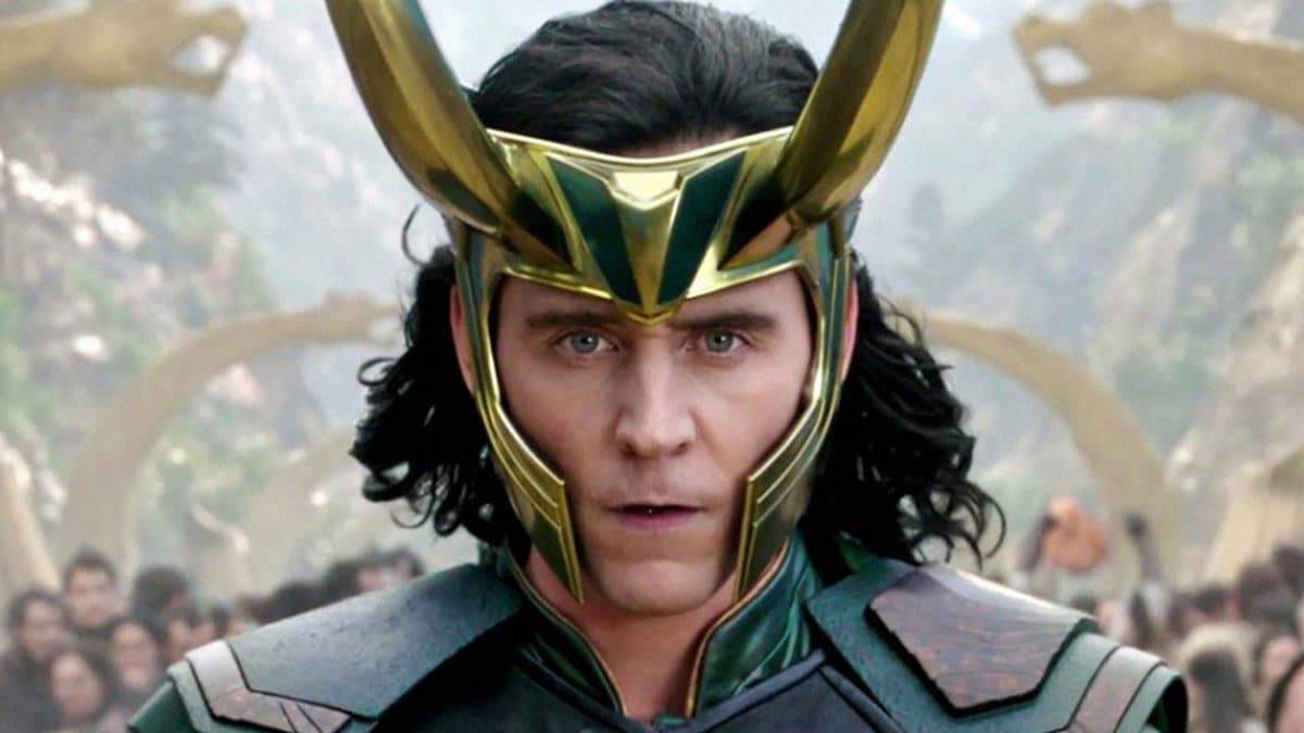 Tom hiddleston interpretando o personagem Loki. Ele está usando o elmo do personagem e suas vestimentas, com um semblante sério no rosto.