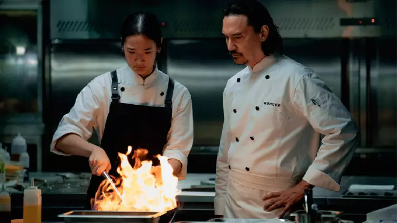 chefe asiático e cozinheira com panela com fogo no filme fome de sucesso