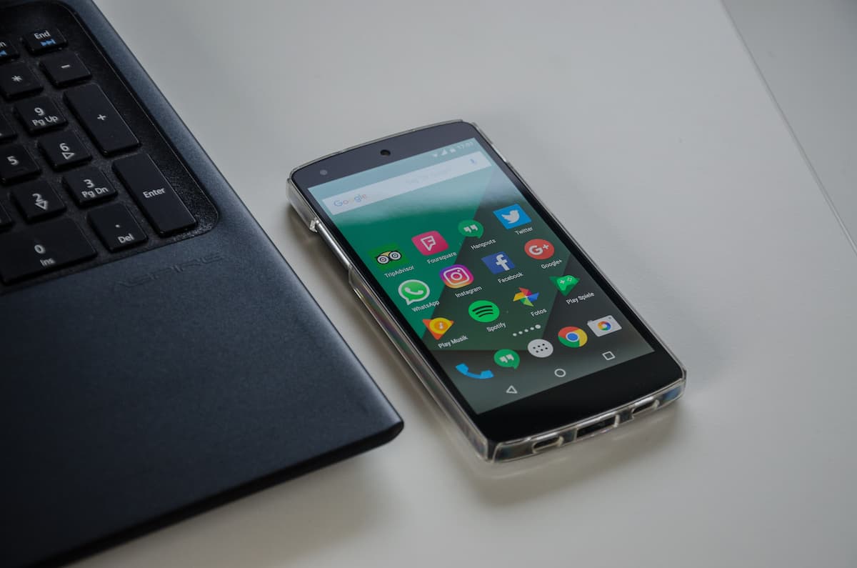 celular android ao lado de computador com vários aplicativos de redes sociais