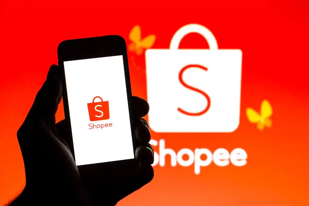 celular com simbolo da shopee e mesma marca ao fundo, aplicativo que oferece super desconto