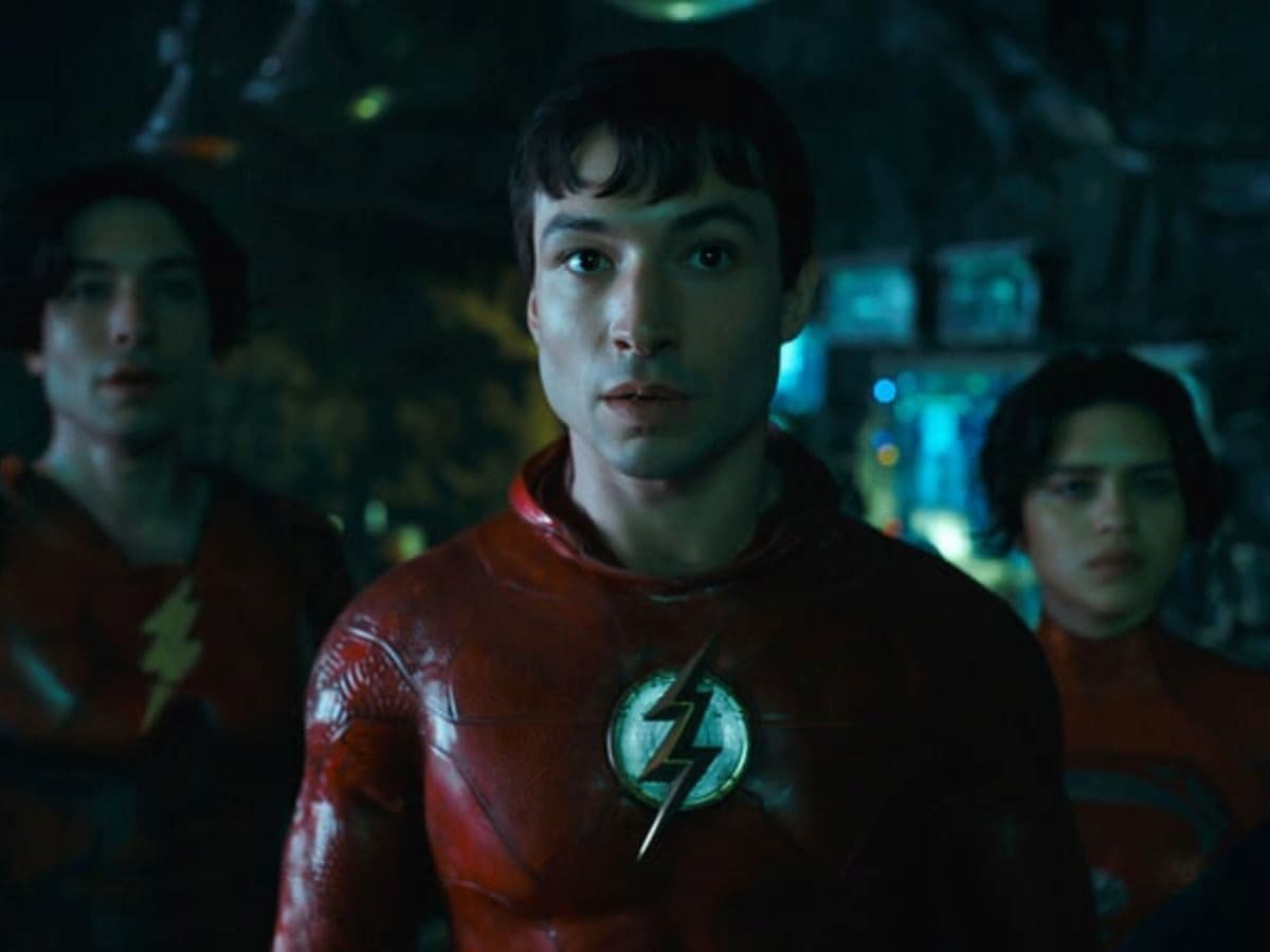 ator ezra miller com uniforme vermelho e simbolo de raio no peito no filme de the flash