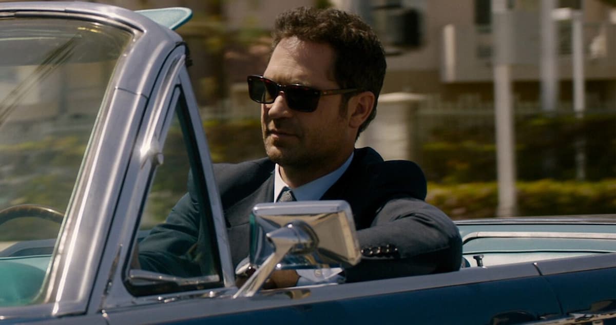 personagem da série o poder e a lei, homem de terno em carro conversível e oculos escuros