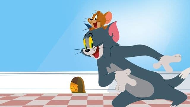 personagens tom e jerry no desenho o show de tom e jerry com parede azul ao fundo com buraco de rato e queijo