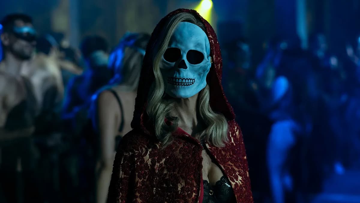 mulher com capuz vermelho e mascara de caveira em festa na série de terror a queda da casa de usher