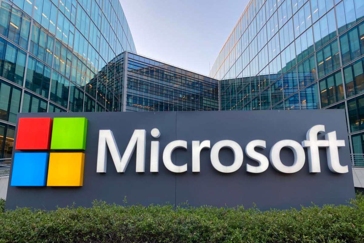Microsoft. Placa com nome e logo da Microsoft entre dois grandes prédios comerciais.