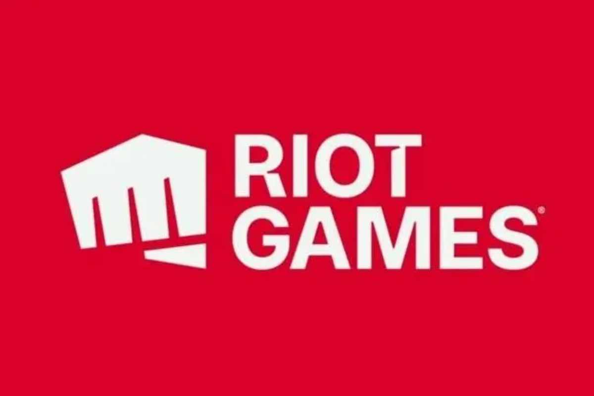 Logo da Riot Games, uma mão em formato de soco, ao lado do nome da empresa em um fundo vermelho.