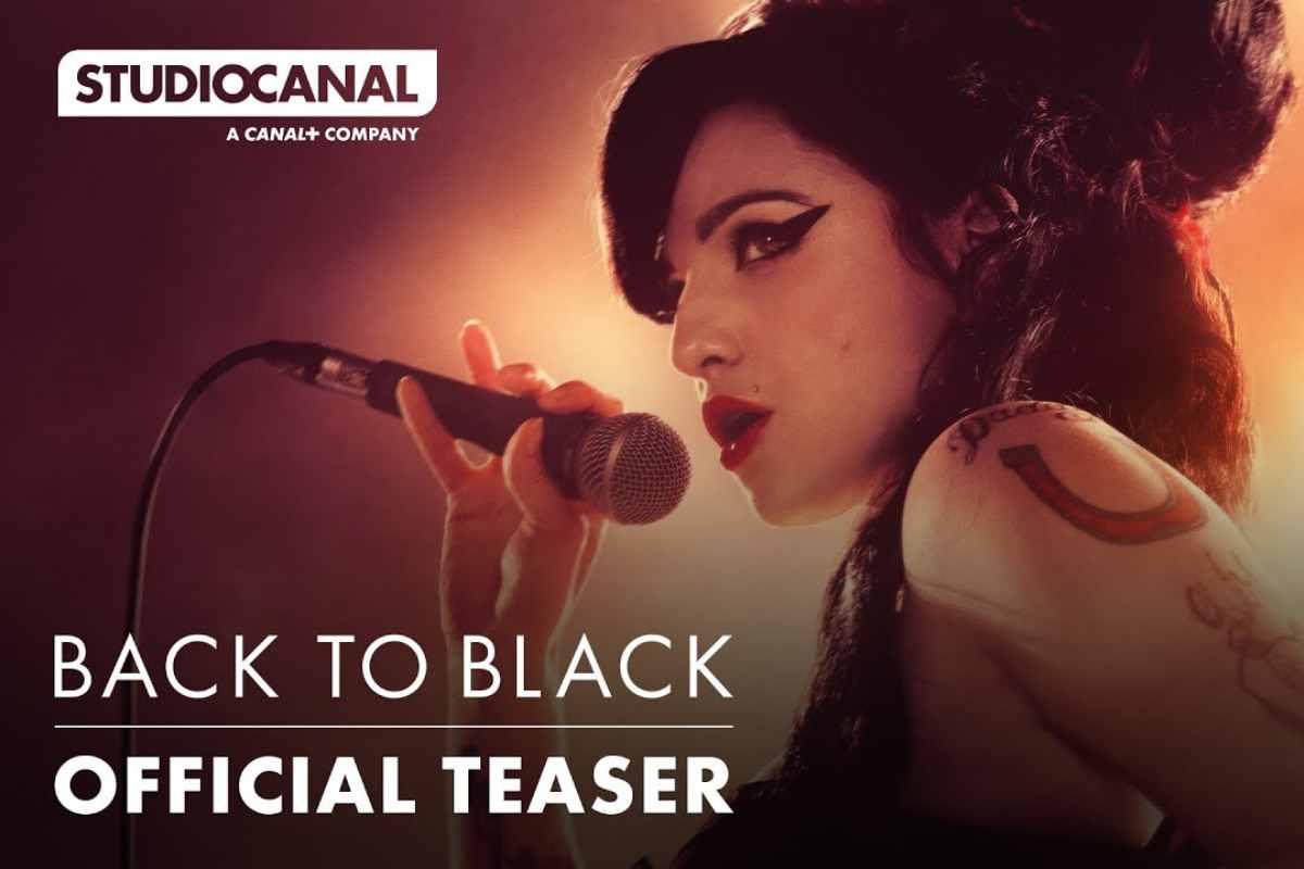 Amy Winehouse Back to Black. Thumbnail do teaser do filme biográfico da Amy Winehouse, Back to Black. nele, a intérprete está de lado segurando um microfone enquanto canta. Sobreposto à imagem está o nome da produtora do filme, a Studiocanal, o título do filme e "official teaser"